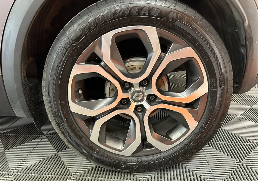 Gros plan sur la roue avant gauche du Renault Captur gris, mettant en valeur la jante alliage à design moderne.