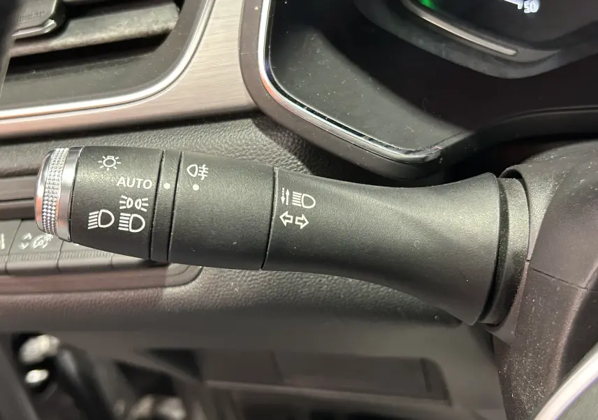 Gros plan sur la commande des feux et clignotants du tableau de bord intérieur du Renault Captur gris 2020.