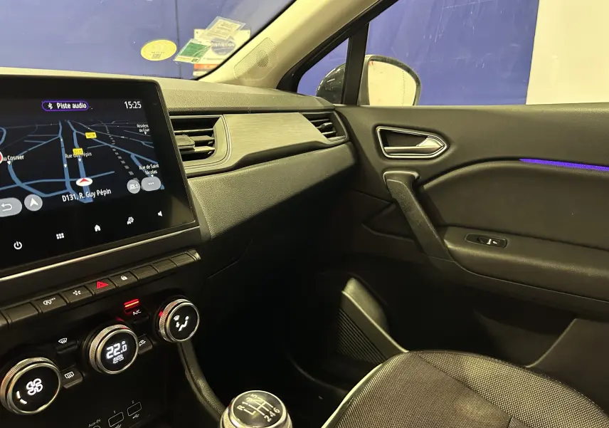 Intérieur du Renault Captur gris, vue côté passager avec écran GPS allumé et détails de la console centrale.