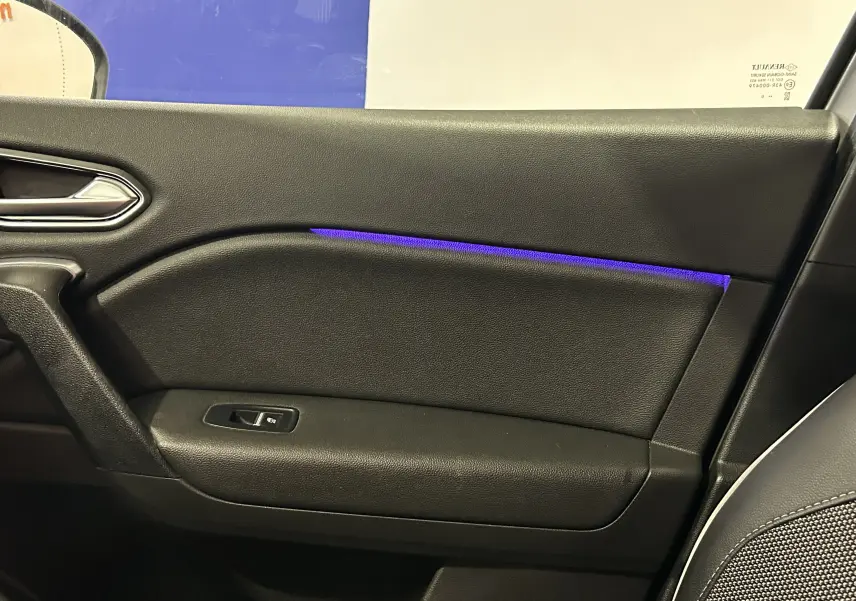 Gros plan sur la porte intérieure côté droit du Renault Captur 2020, avec éclairage d'ambiance bleu et garniture noire.