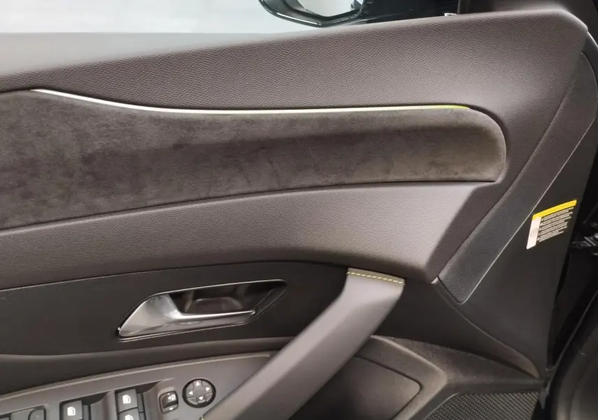 Détail de la porte avant gauche de la Peugeot 308 noire, avec surpiqûres vert Adamite et insert alcantara.
