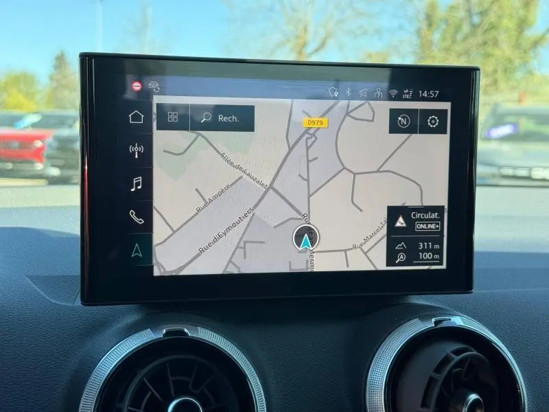 Écran central tactile affichant la navigation GPS dans l'Audi Q2 35 TDI S line 2025, intérieur avec aérateurs ronds visibles.