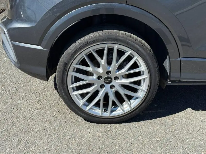 Gros plan sur la roue avant gauche d’un Audi Q2 35 TDI S line 2025 en gris Daytona nacré avec jante alliage multibranches.