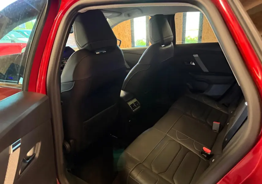 Vue intérieure côté gauche sur l'arrière d'une Citroën C4 X rouge de 2021, sièges arrière en tissu noir avec surpiqûres.