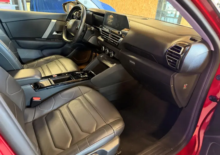 Intérieur noir cuir de la Citroën C4 X 2021, vue côté passager avec tableau de bord moderne et écran tactile central.