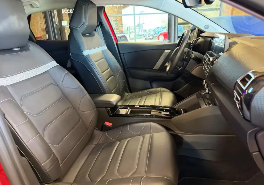 Intérieur avant du Citroën C4 X 2021 en cuir noir, vue côté gauche avec tableau de bord et console centrale visibles.