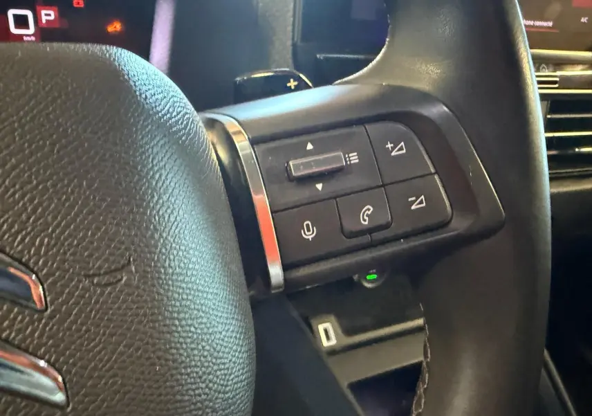 Gros plan sur la partie droite du volant noir de la Citroën C4 X 2021, avec commandes audio et téléphone intégrées.