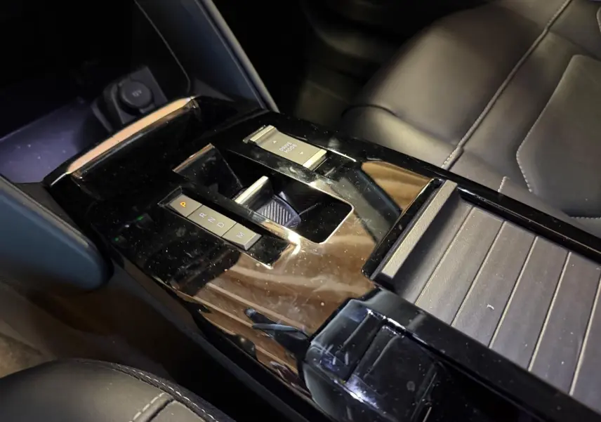 Vue rapprochée de la console centrale noire brillante avec sélecteur de boîte auto et bouton Drive Mode du Citroën C4 X 2021.