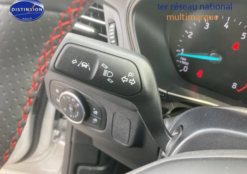 Gros plan sur la manette de clignotants et volant avec surpiqûres rouges de la Ford Focus gris 2025.