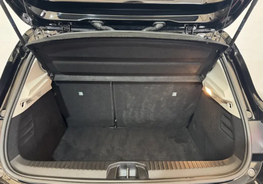 Coffre ouvert de la Renault Clio Business E-Tech hybride noir, vue intérieure arrière montrant la banquette rabattable 2/3-1/3.