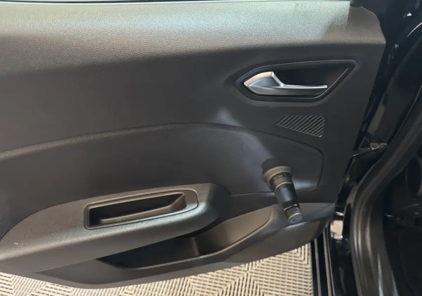 Vue intérieure côté gauche de la porte arrière noire de la Renault Clio Business E-Tech hybride 2021 avec poignée manuelle de vitre.