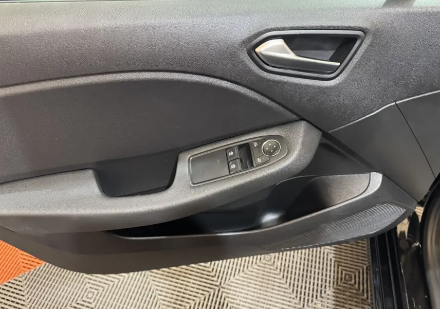 Vue rapprochée de la porte intérieure côté gauche de la Renault Clio Business E-Tech noire, avec commandes électriques des vitres.