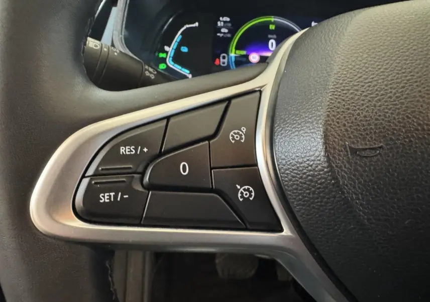Gros plan sur les commandes de régulateur de vitesse au volant cuir d’une Renault Clio Business E-Tech hybride 2021.