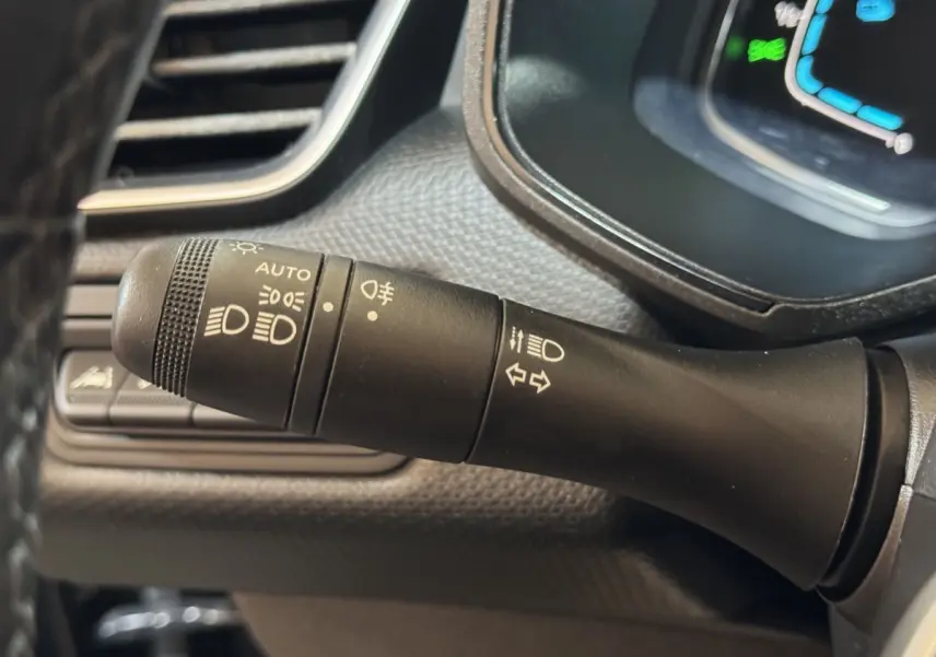 Gros plan sur la commande des phares et clignotants dans l’habitacle noir de la Renault Clio Business E-Tech hybride 2021.