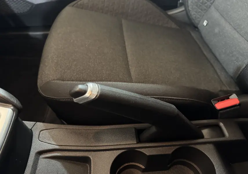 Vue rapprochée de la console centrale intérieure de la Renault Clio Business E-Tech hybride 2021, montrant le frein à main manuel et la banquette arrière noire.