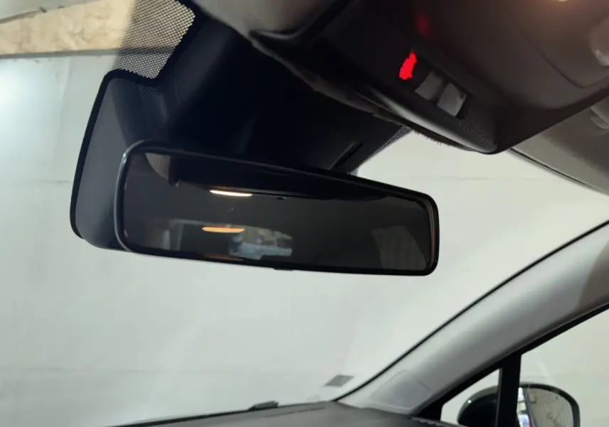 Vue intérieure centrée sur le rétroviseur intérieur d'une Renault Clio noire, avec plafond et pare-brise visibles.