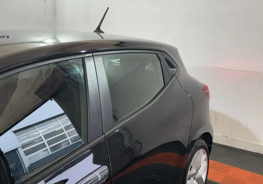 Détail du côté gauche arrière d’une Renault Clio Business E-Tech hybride noire, avec vitre et jante visible.