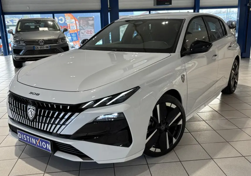 Vue 3/4 avant droite d'une Peugeot 308 blanche avec calandre noire à liserés chromés et jantes alliage bi-ton.