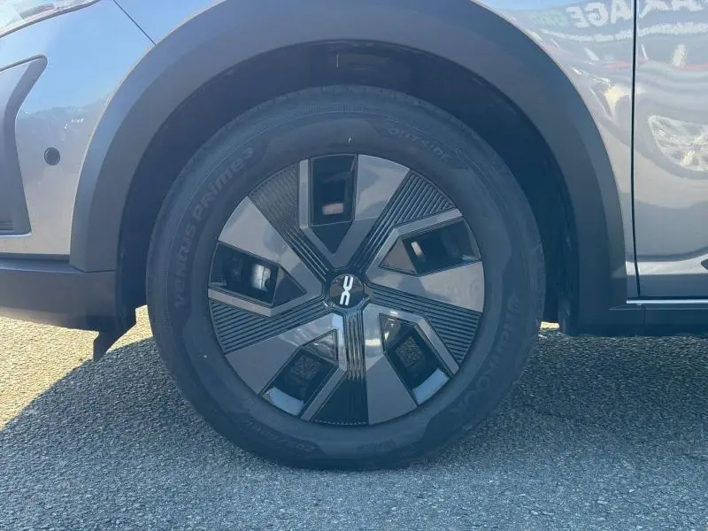 Gros plan sur la roue avant gauche du Dacia Jogger 2025 gris schiste métallisé avec jante au design géométrique noir et gris.