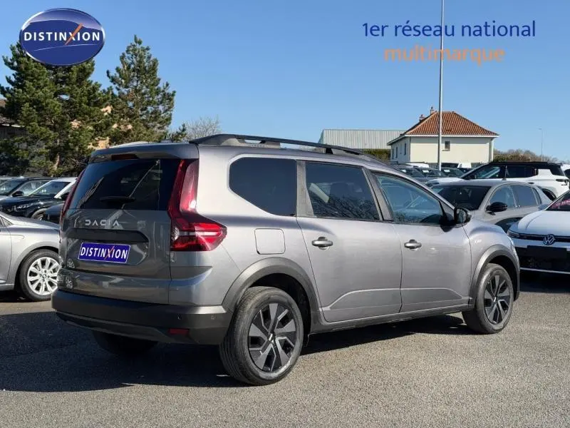 Vue 3/4 arrière droite d'un Dacia Jogger gris schiste métallisé 2025 avec toit noir et jantes alliage distinctives.