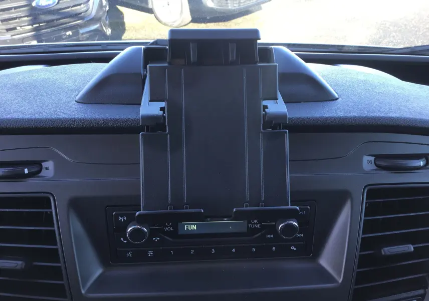 Vue rapprochée du tableau de bord du Ford Transit Chassis Cabine blanc 2024, avec support tablette et radio intégrée.