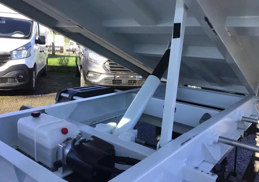 Gros plan sur le mécanisme de levage hydraulique blanc de la benne arrière d’un Ford Transit Chassis Cabine blanc.