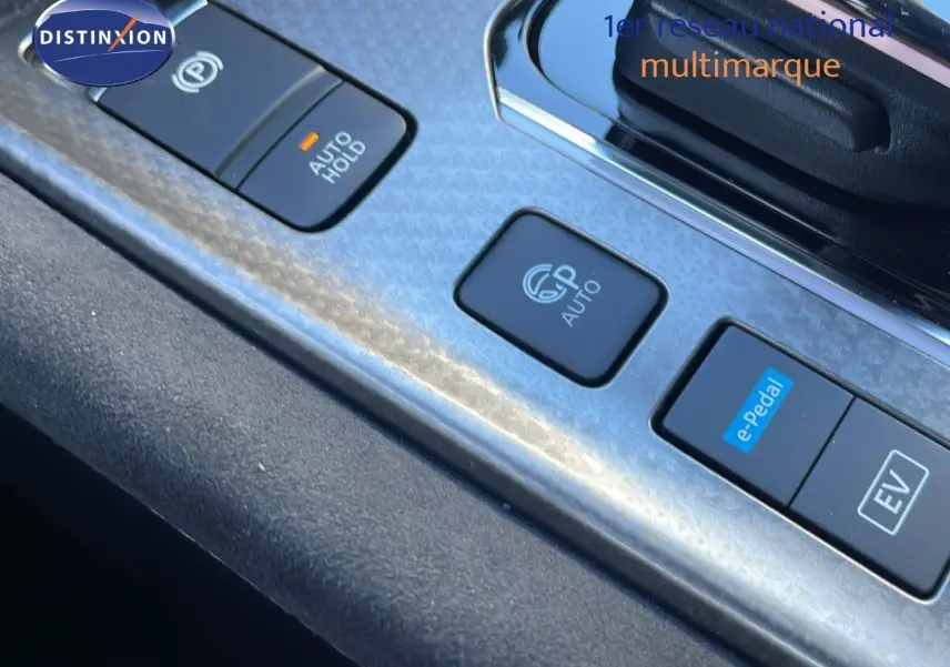 Gros plan sur les commandes de la console centrale du Nissan Qashqai blanc nacré avec finition N-Design, boutons e-Pedal et EV visibles.