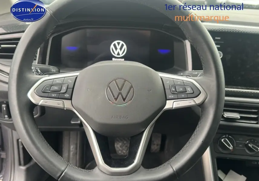 Vue rapprochée du volant cuir multifonction d'une Volkswagen Polo 2025, avec tableau de bord digital et commandes intégrées.