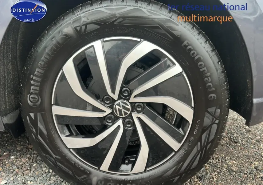 Gros plan sur la jante alliage 15 pouces noire et argentée d'une Volkswagen Polo gris cendre, côté avant droit.