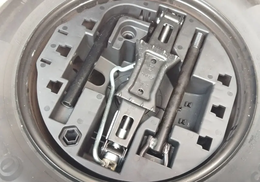 Gros plan sur la roue de secours et le cric dans le coffre d’une Renault Clio 1.0 SCe 65ch Evolution 2022 Bleu Iron.