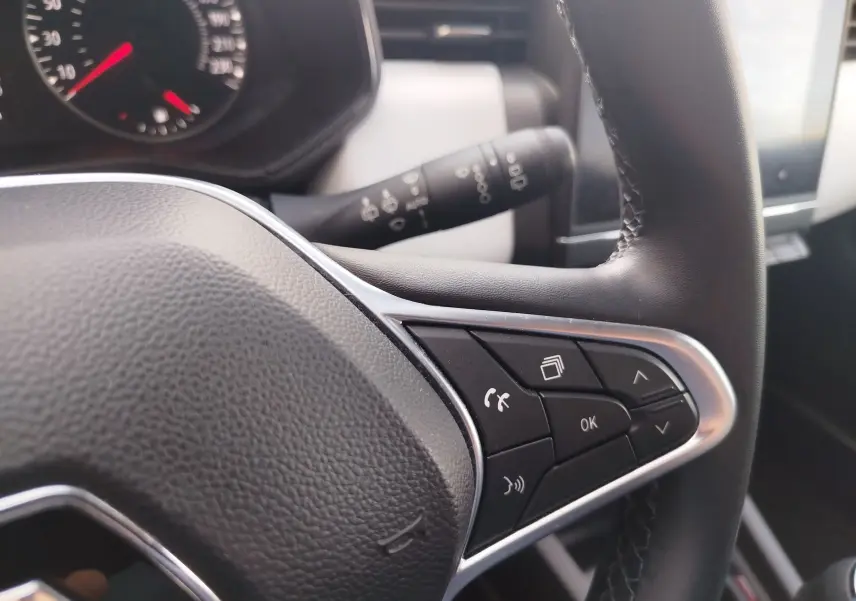 Gros plan sur le volant côté droit de la Renault Clio 1.0 SCe 65ch Evolution 2022 avec commandes multifonctions et finition noire.