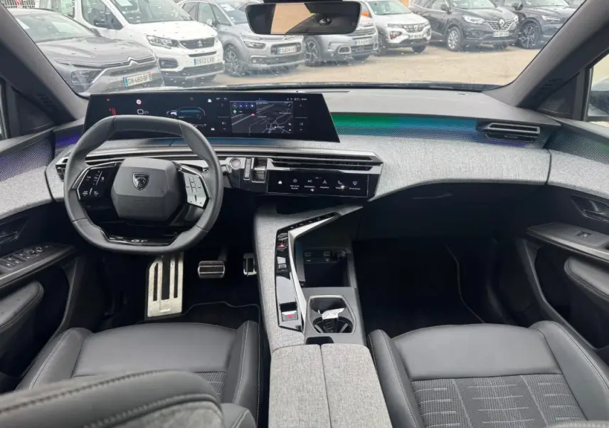Vue intérieure avant du Peugeot 5008 Hybrid 145 ch e-DCS6 GT 2025, tableau de bord moderne avec cockpit numérique et sellerie noire.