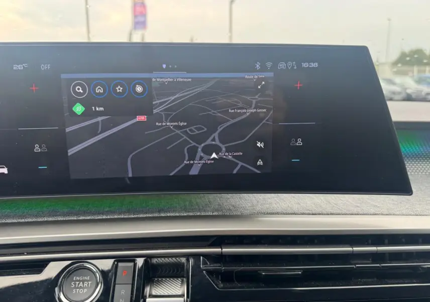 Vue rapprochée du cockpit numérique du Peugeot 5008 Hybrid 145 ch GT 2025, affichant la navigation et le bouton start/stop.