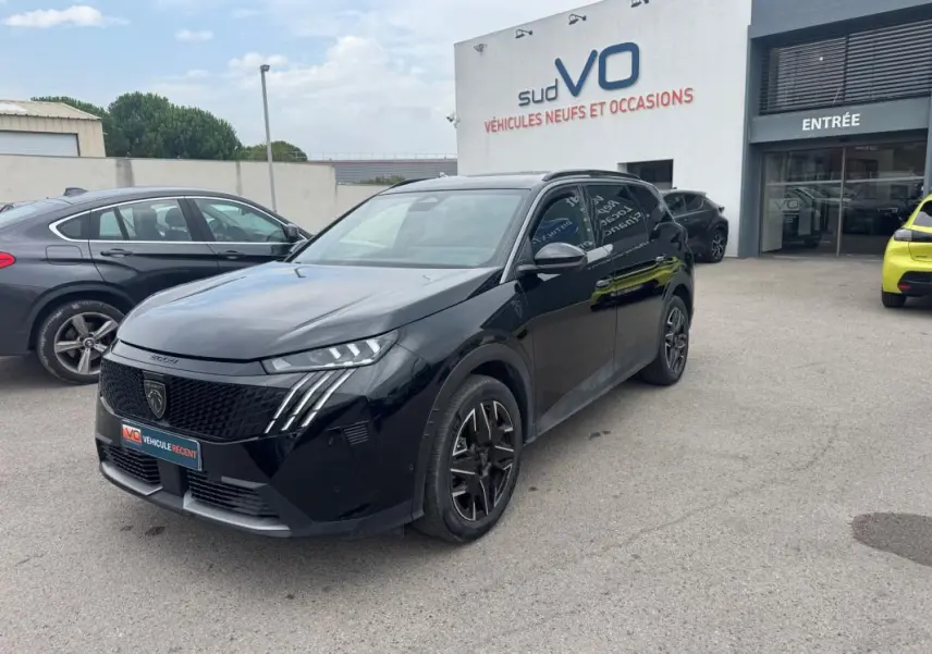 Peugeot 5008 Hybrid noir vue 3/4 avant droit, jantes alliage 19 pouces, barres de toit et calandre distinctive.