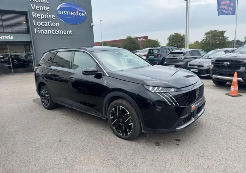 Peugeot 5008 Hybrid noir vue 3/4 avant gauche, avec jantes alliage noires et barres de toit visibles.