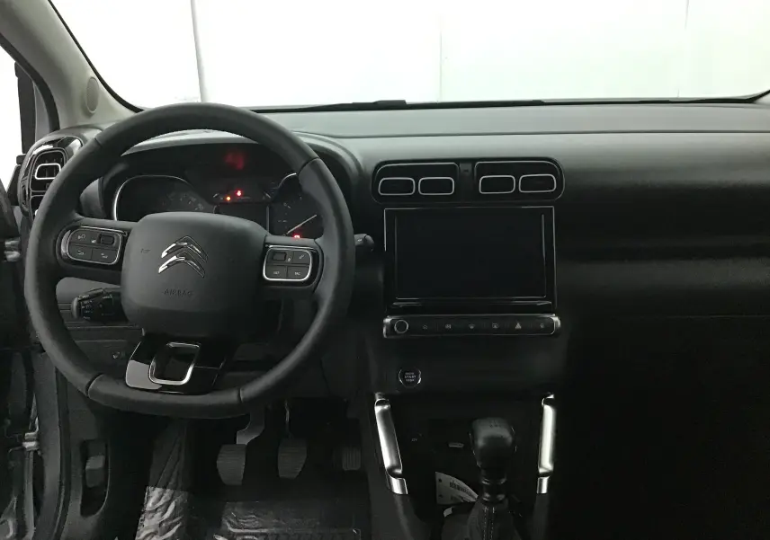 Vue intérieure du tableau de bord et volant du Citroën C3 Aircross 2024, avec écran tactile et commandes au volant.