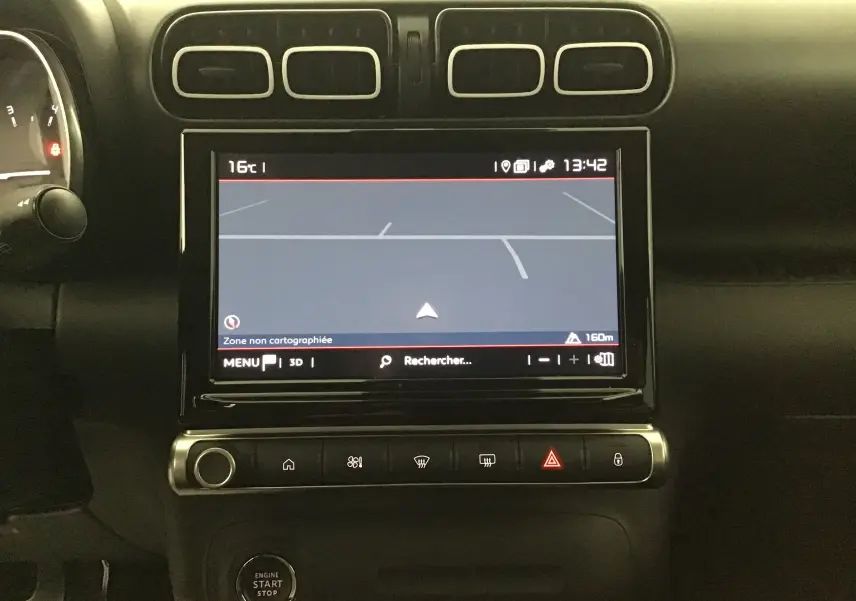Vue rapprochée du tableau de bord noir du Citroën C3 Aircross 2024 avec écran tactile affichant la navigation.