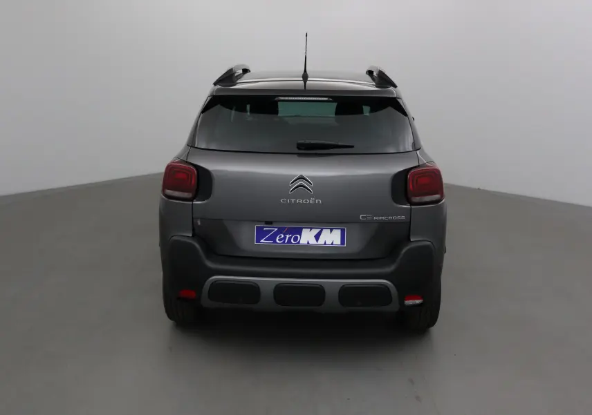 Vue arrière d'un Citroën C3 Aircross gris platinium avec toit noir et feux arrière distinctifs en forme carrée.