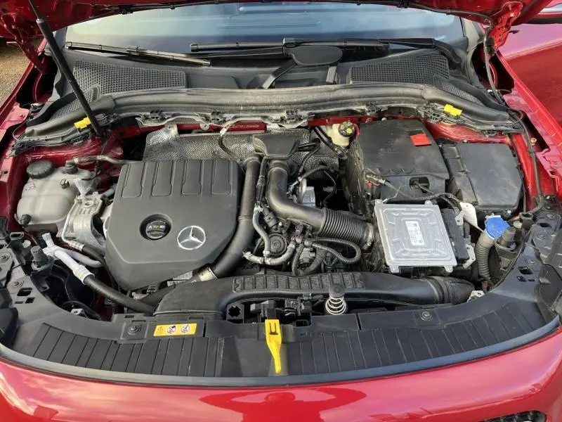 Vue plongeante sur le moteur d'une Mercedes GLA 200 Business Line rouge Patagonie métallisé designo, capot ouvert.