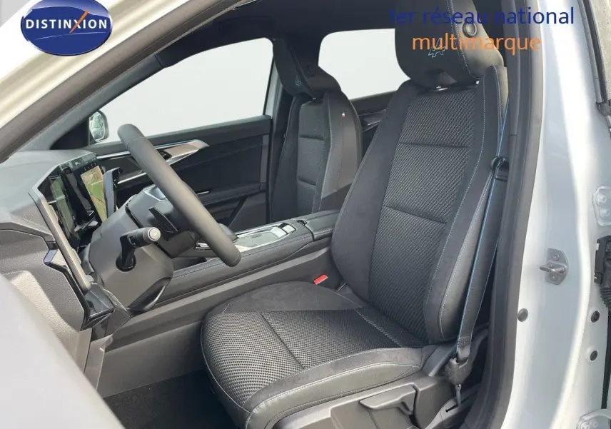 Intérieur du Renault Austral E-Tech hybride 2025, vue côté conducteur, sièges noirs en cuir et alcantara avec surpiqûres bleues.