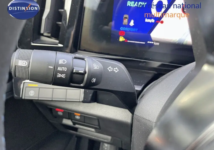 Gros plan sur la commande des phares et clignotants à gauche du volant du Renault Austral blanc nacré 2025.