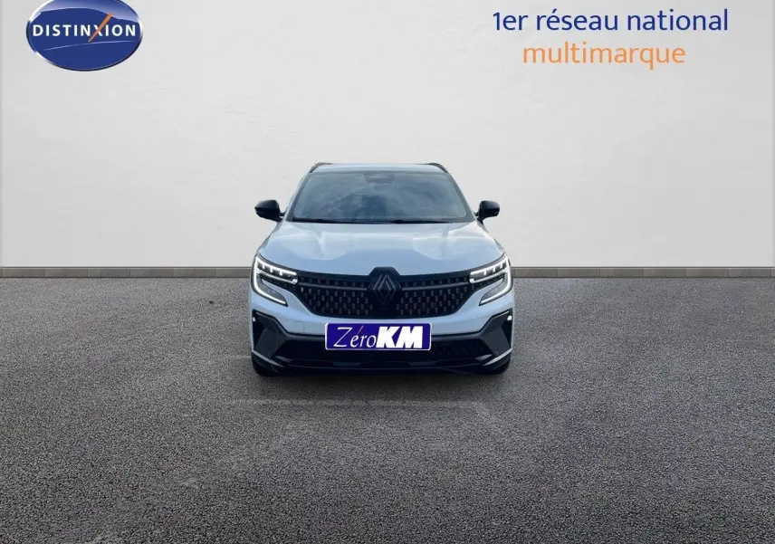 Vue de face du Renault Austral blanc nacré avec calandre noire et phares LED allumés sur fond neutre.