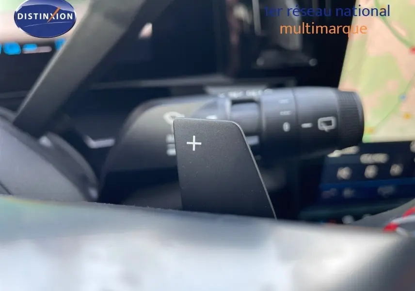 Gros plan sur la palette de changement de vitesse droite dans l'habitacle noir du Renault Austral blanc nacré.