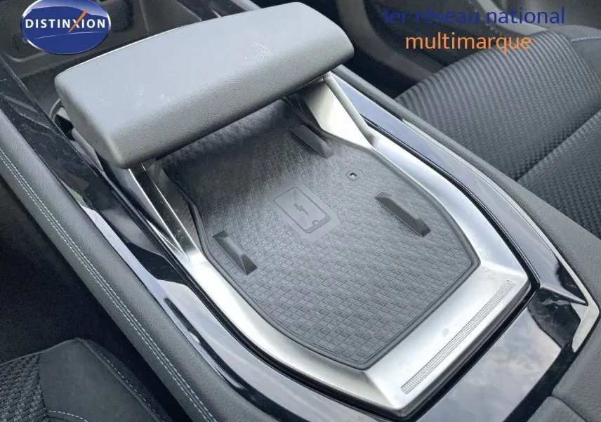 Plateau de recharge sans fil et accoudoir central dans l'habitacle du Renault Austral E-Tech blanc nacré 2025.