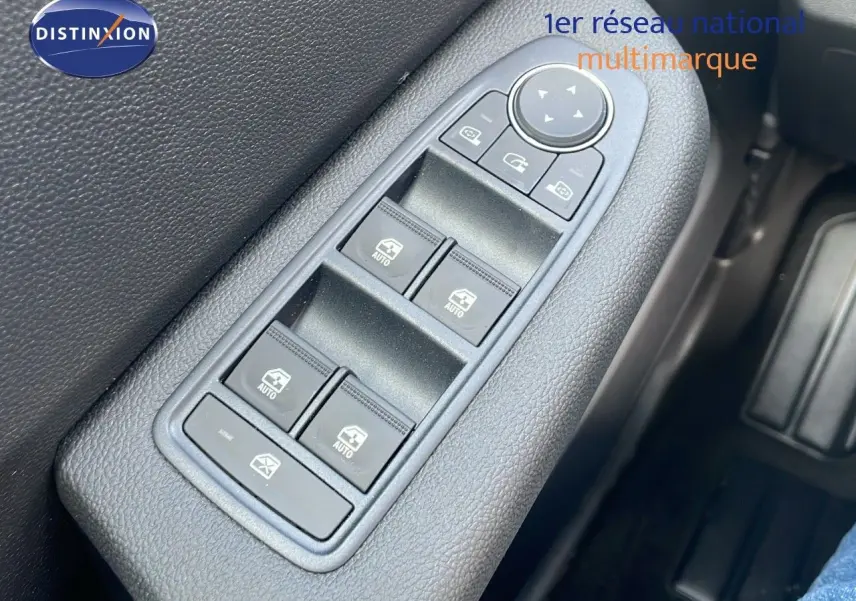 Panneau de commandes des vitres électriques côté conducteur dans une Renault Clio gris schiste métal, intérieur noir.