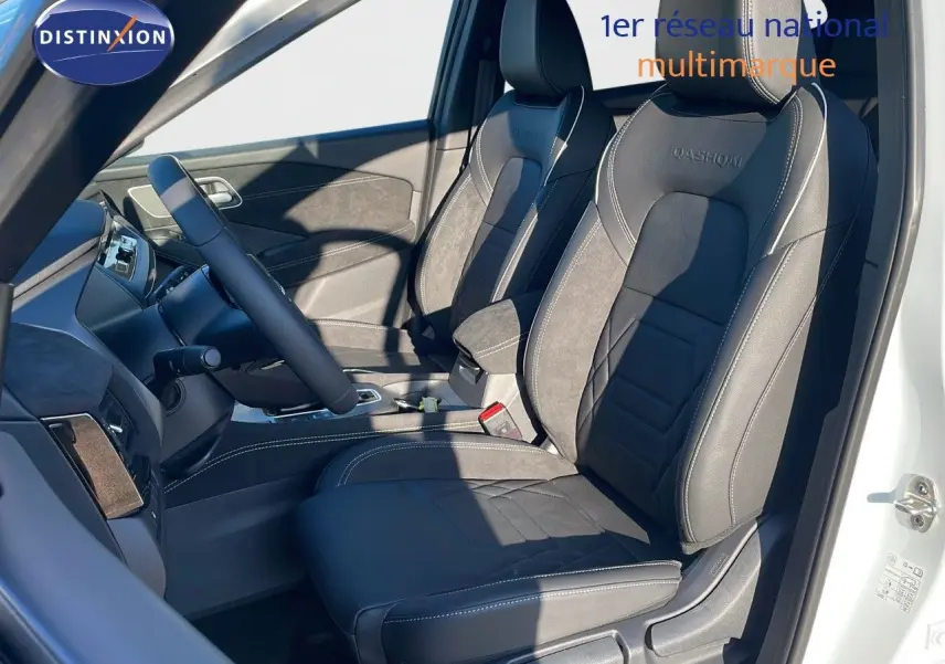 Intérieur côté conducteur du Nissan Qashqai 2025 blanc nacré, sièges cuir noir N-Design avec surpiqûres blanches.