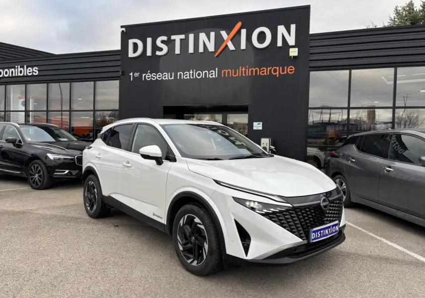 Nissan Qashqai III blanc nacré en 3/4 avant droit, avec calandre noire et jantes alliage noires distinctives.