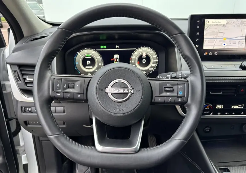 Vue centrée sur le volant cuir noir du Nissan Qashqai III 2025 avec tableau de bord numérique et écran tactile GPS.