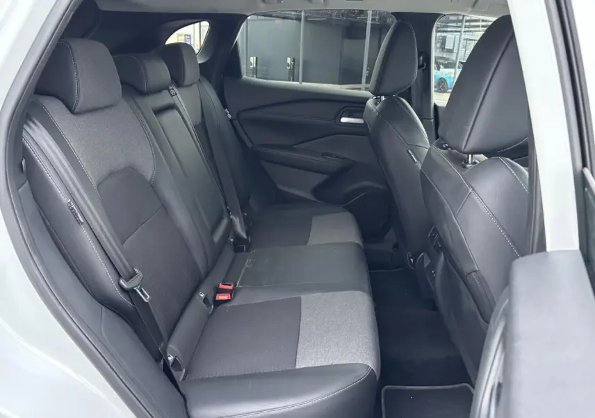 Vue intérieure côté droit montrant la banquette arrière mixte tissu et TEP noire du Nissan Qashqai blanc nacré 2025.