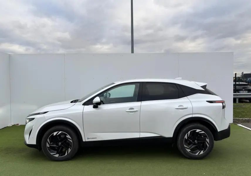 Vue de profil côté gauche du Nissan Qashqai III blanc nacré avec jantes alliage noires et toit contrasté noir.